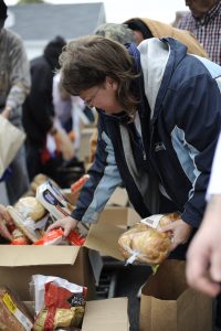 Corporate Photo Female client selects takes grains rolls Ramen bread Weight Watchers out of a box outside outdoor pantry many clients